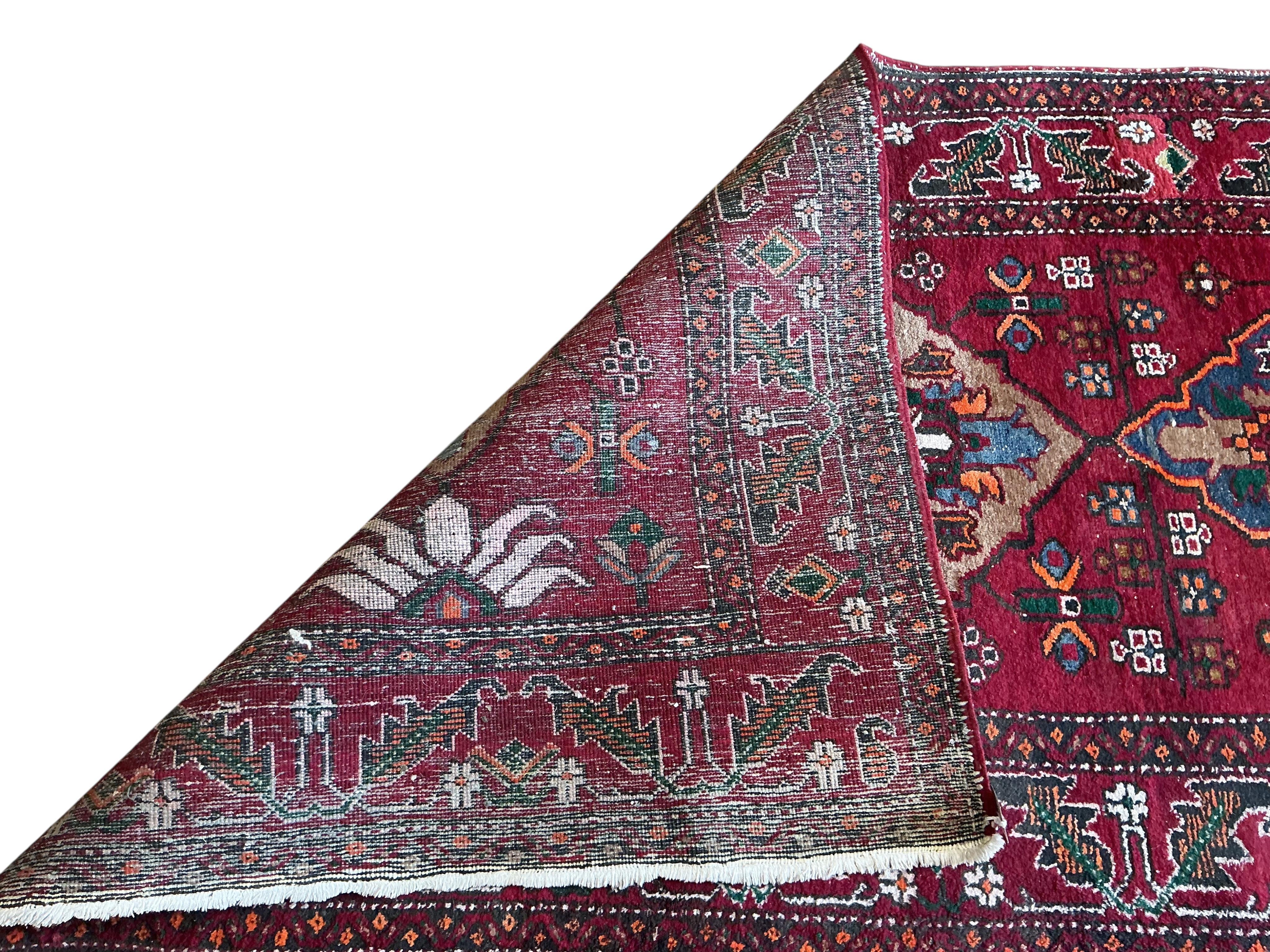 A Caucasian red ground runner, woven with four central elongated octagons, 433 x 113cm